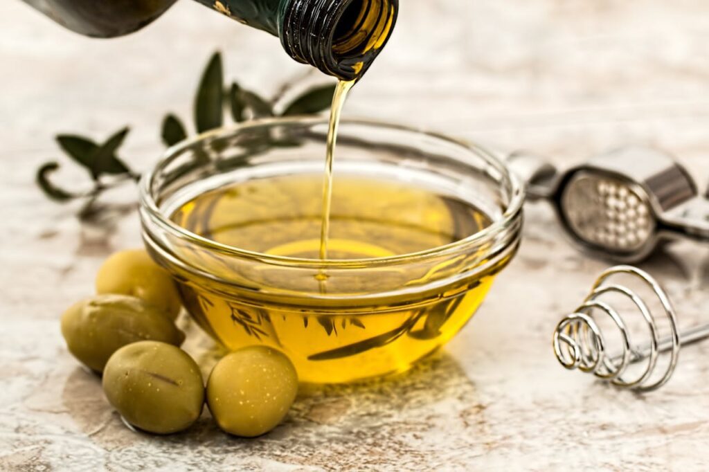 Top Anti‑Inflammatory Foods to Reduce Belly Fat for Women Over 40 16 Extra virgin olive oil in a glass bottle with olives – a top anti-inflammatory food that supports belly fat reduction for women over 40.